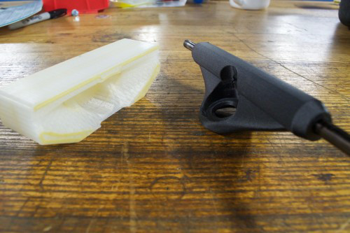 The custom 3D printed fixture for holding the truck in the vice.