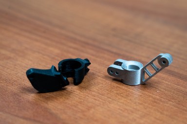 Broken plastic part next to metal 3D printed part