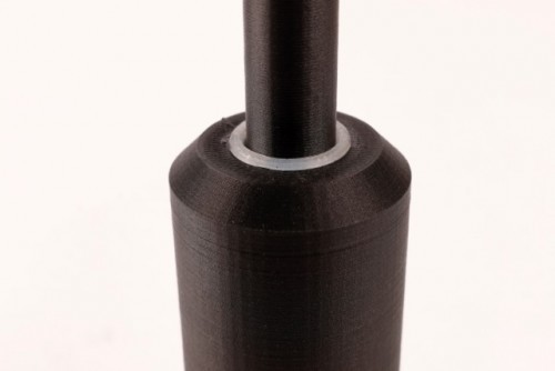 The 3D printed bushing gets added in after a second pause in the print.