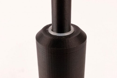 The 3D printed bushing gets added in after a second pause in the print.