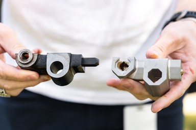 Original actuator housing held next to 3D printed housing version